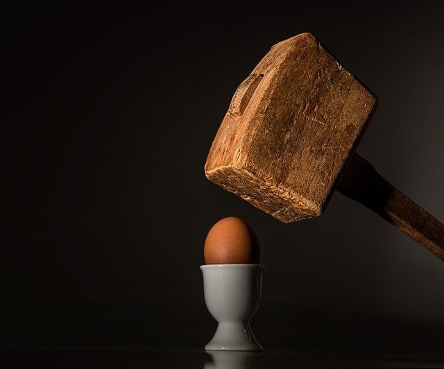 A mallet about to smash an egg, symbolising brand damage in mining recruitment.