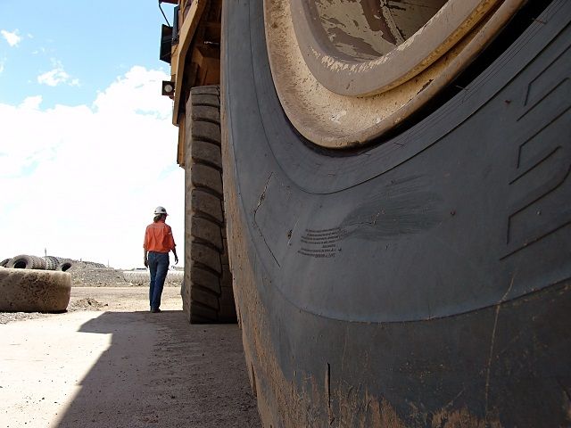 woman walking alongside mining machinery