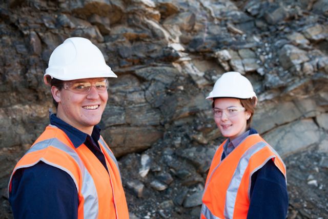 Mining team, male and female looking at rock face