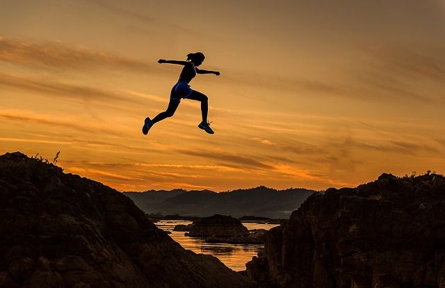 Woman jumping over a wide gap