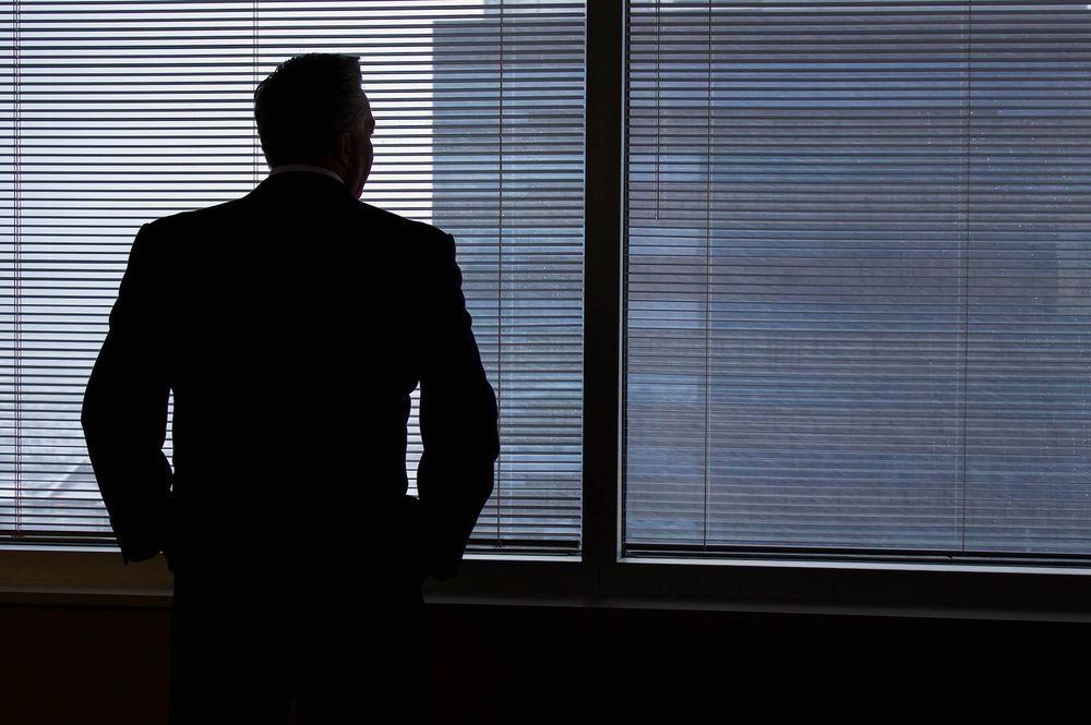 business man looking out of window and thinking of quitting