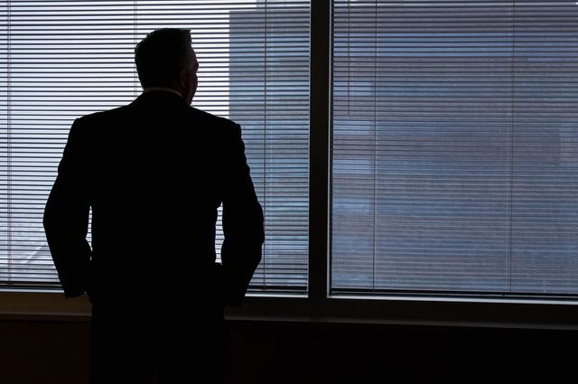 business man looking out of window and thinking of quitting