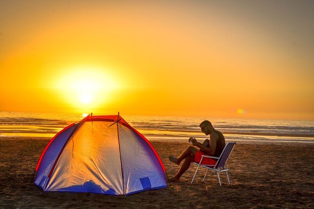 Man playing guitar at his camp site