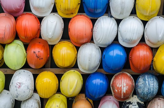 A wall of colourful hard hats