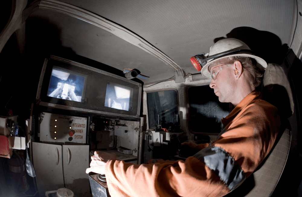 Miner sitting in a control room operating machinery