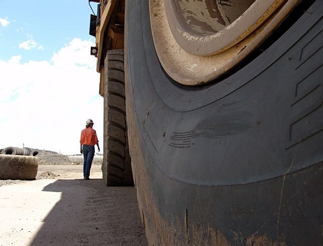 woman walking alongside mining machinery