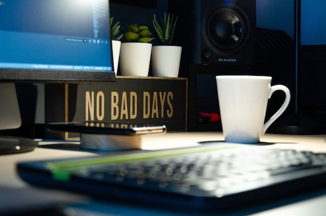 An office desk with a mug and a sign that says “no bad days”.