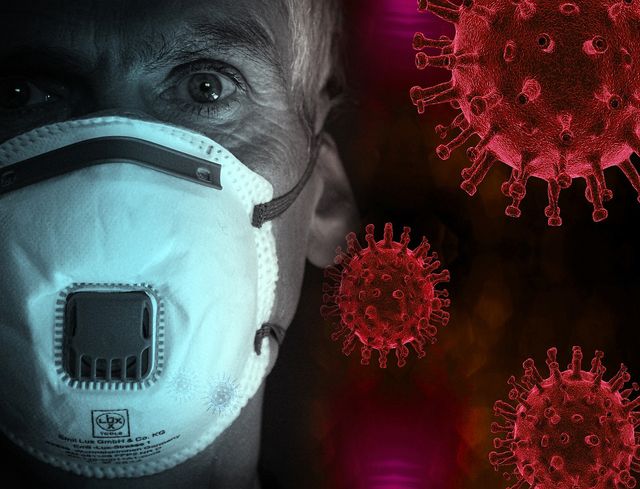 A composite image of a man in a face mask with coronavirus all around him.
