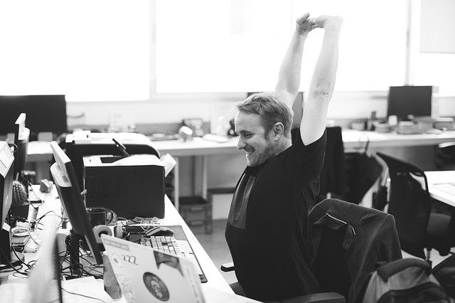 Picture of a man stretching at his desk