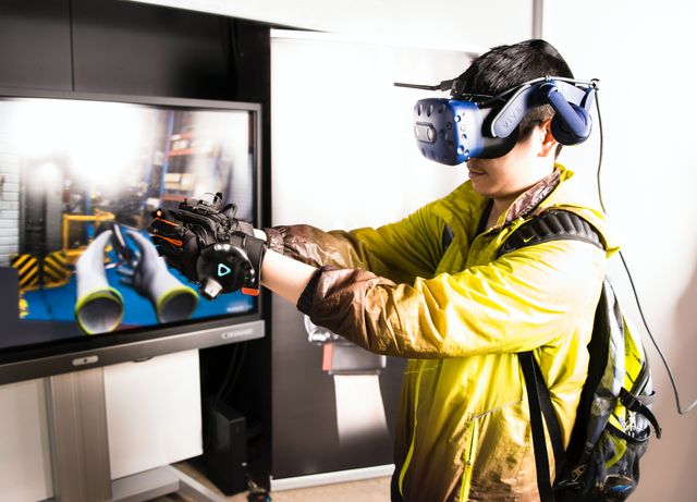 A man works in mining’s metaverse, wearing a virtual reality headset.