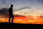 Silhouette of miner in front of a sunset