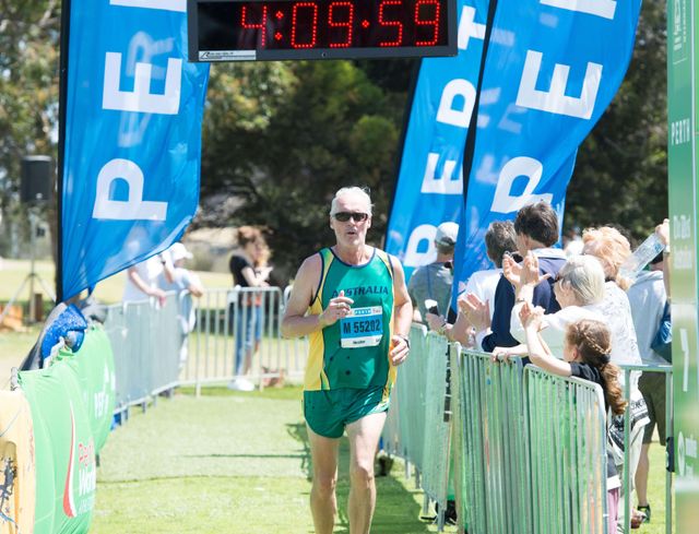 Steve Heather crossing the finish line of the Perth 2016 World Masters Marathon