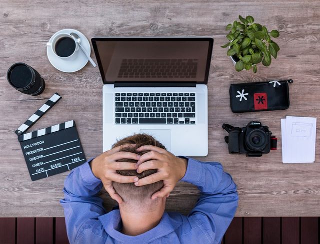 Man with hands on head at desk