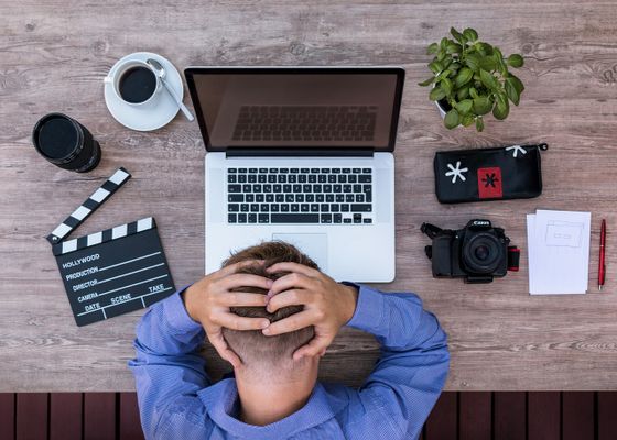 Man with hands on head at desk