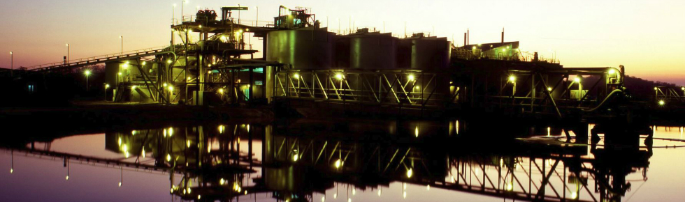 Mining process plant at sunset with refelction in water